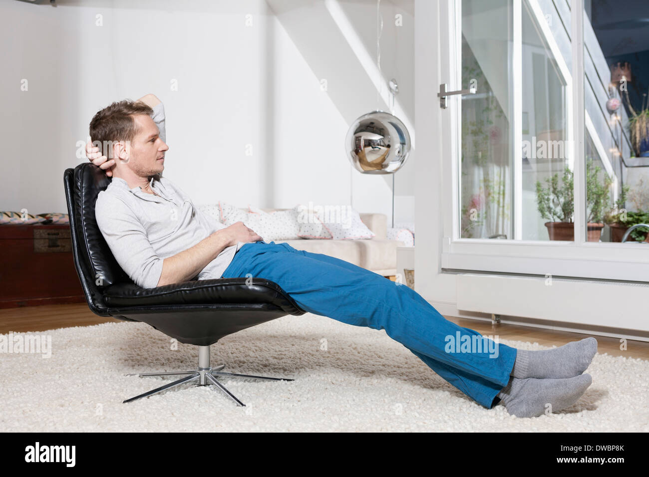 Man relaxing in fauteuil après travaux Banque D'Images