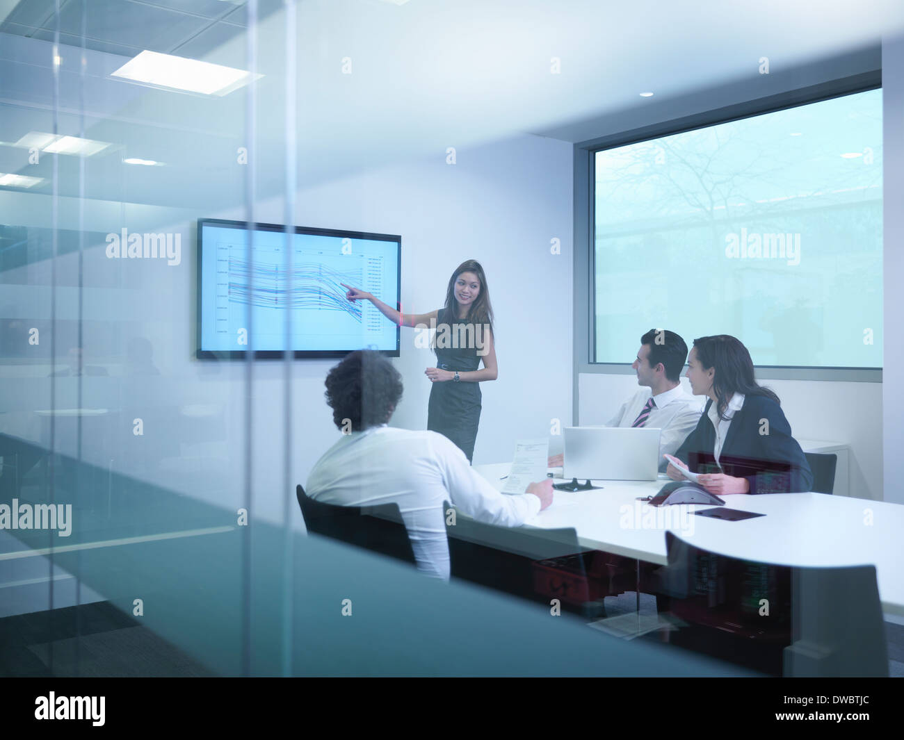 Voir à travers le verre mur de collègues d'affaires à l'aide de l'écran en réunion Banque D'Images