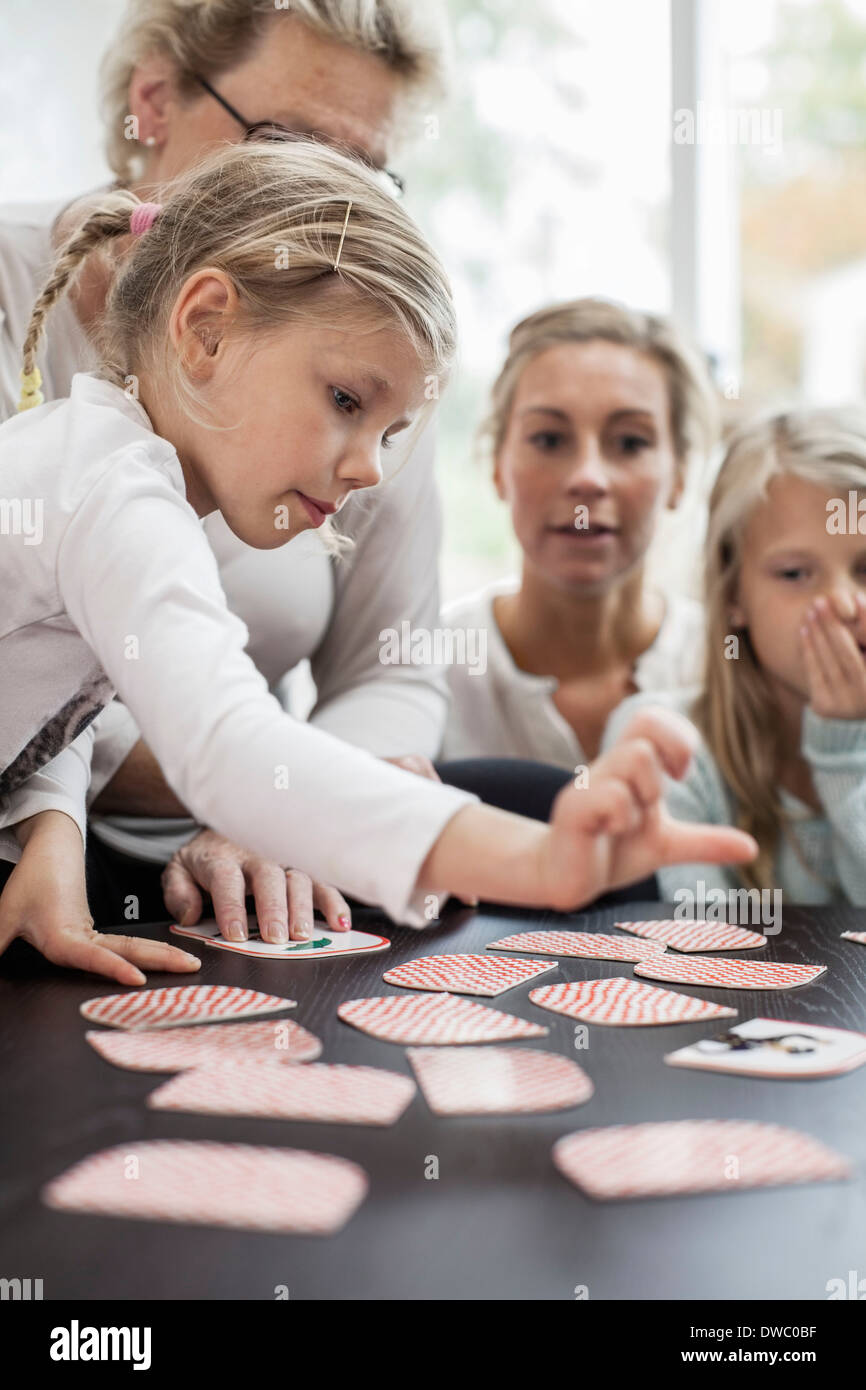 Girl jeu de carte jeu de puzzle avec la famille à la maison Banque D'Images