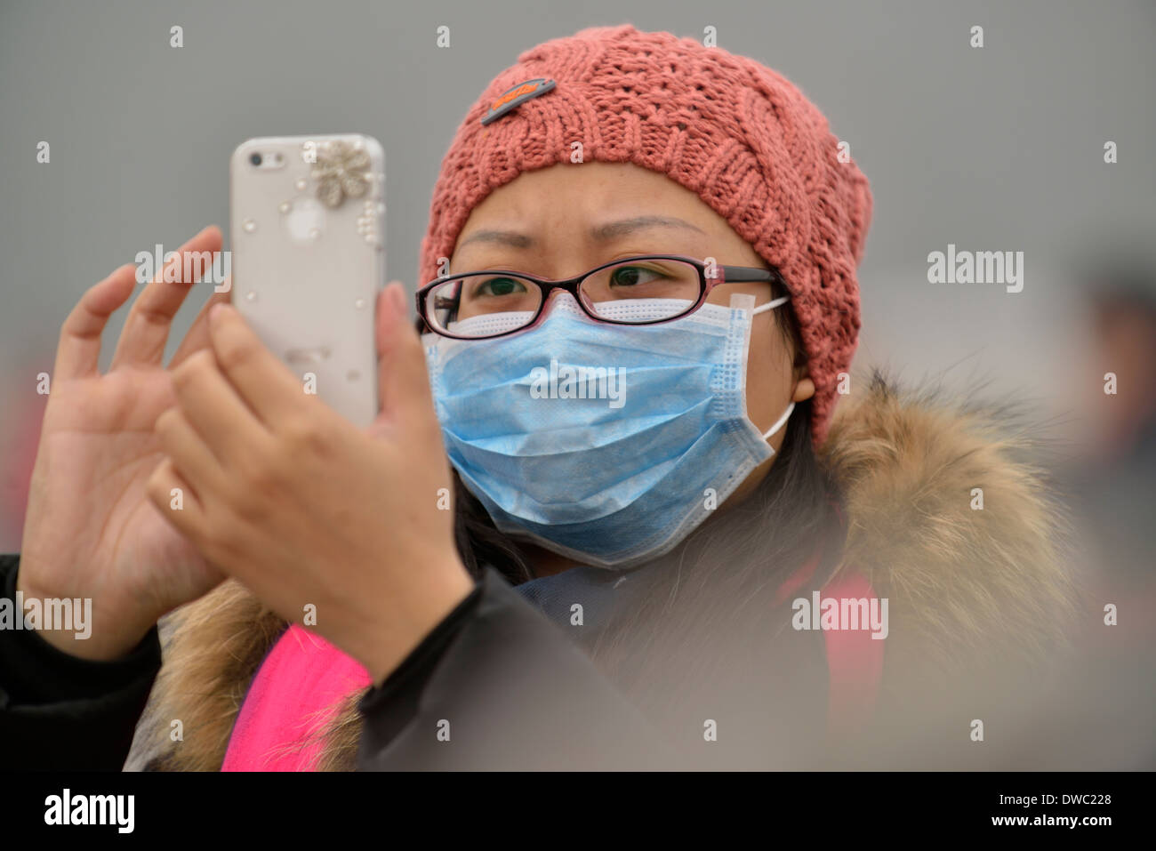 Une dame porte un masque tout en se rendant sur la place Tienanmen à Pékin le 26 février 2014 Banque D'Images