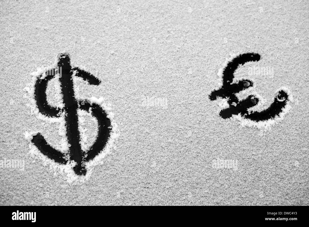 Photo de un dollar et euro sign dessiné dans la neige Banque D'Images