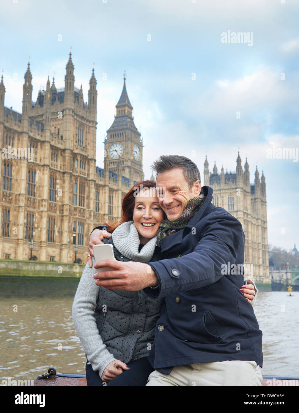 Couple de touristes matures photographier soi-même et des chambres du Parlement, Londres, UK Banque D'Images