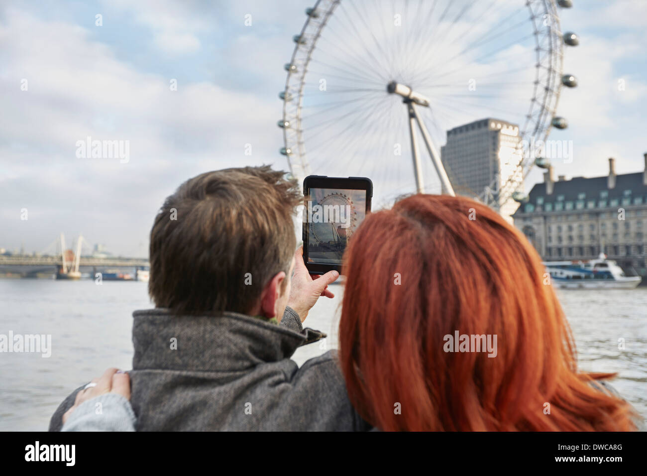 Couple de touristes matures photographie London Eye, London, UK Banque D'Images