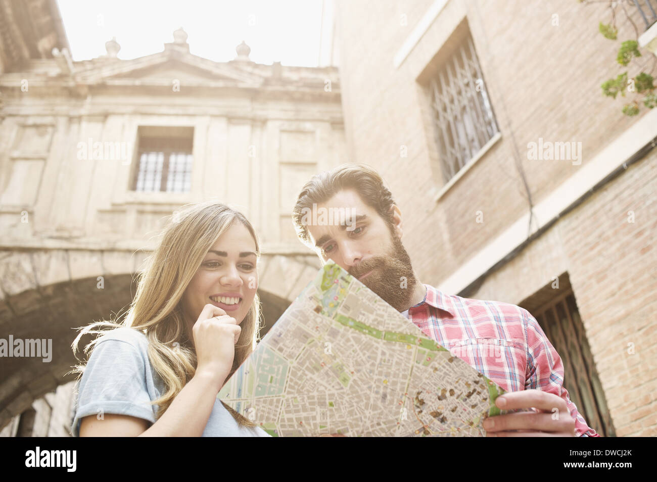 Jeune couple de touristes à la carte à l'extérieur de la cathédrale de Valence, Valence, Espagne Banque D'Images