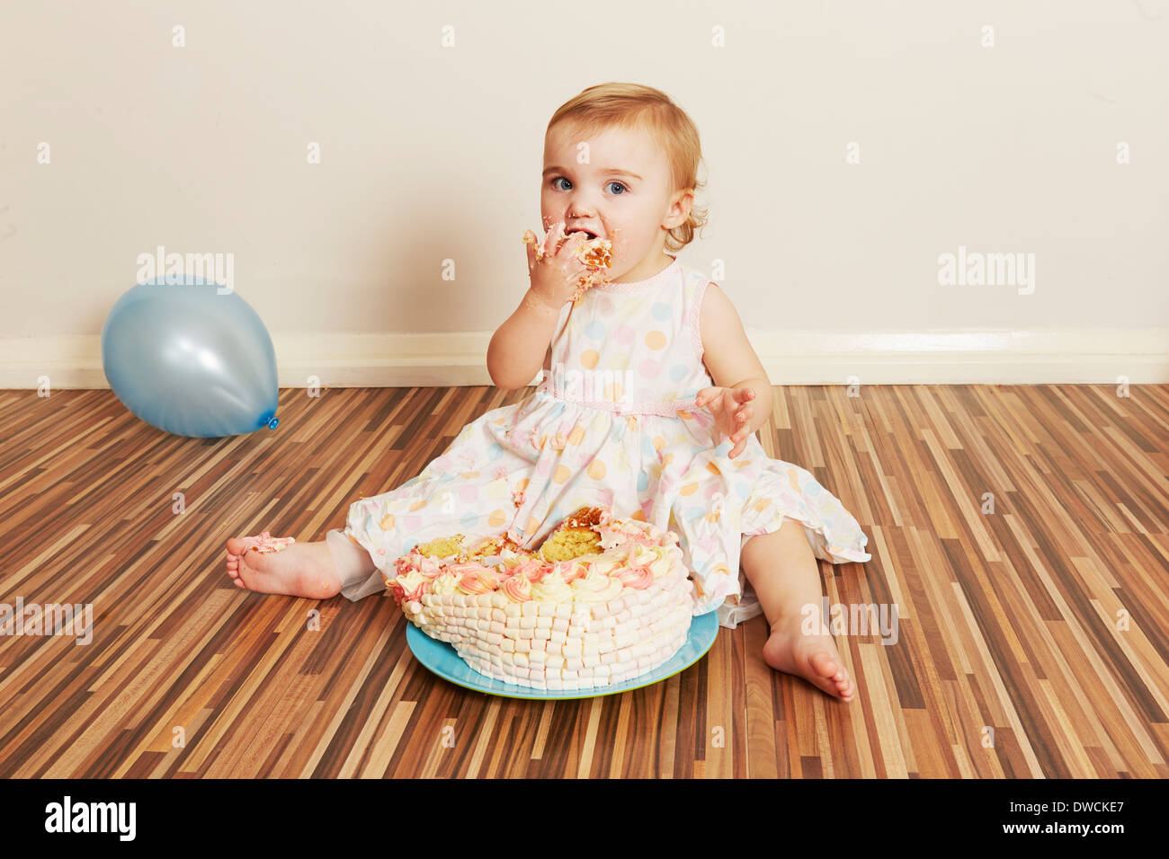 Bébé fille de dévorer le gâteau d'anniversaire Banque D'Images