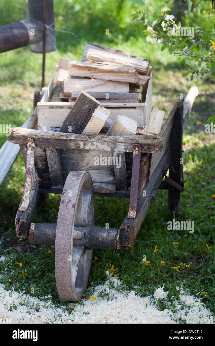 Une brouette en bois ancien chargé de bois de chauffage Banque D'Images