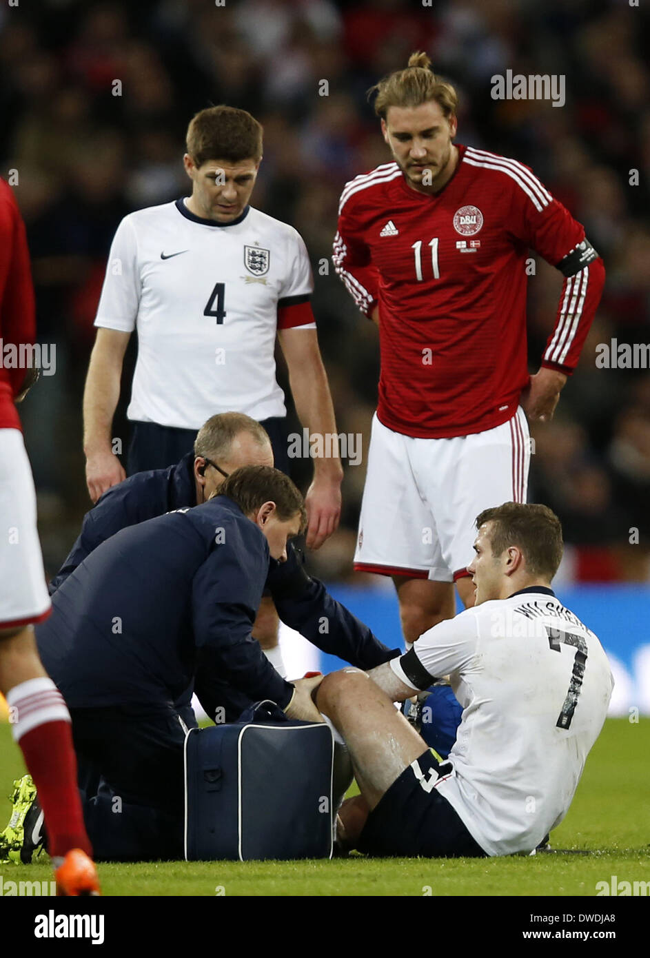 Londres, R) du Danemark ressemble au cours d'un match de football amical entre le Royaume-Uni et le Danemark au stade de Wembley à Londres. 5Th Mar, 2014. Jack Wilshere(1R) d'Angleterre reçoit un traitement médical après une blessure comme son coéquipier Steven Gerrard(L) et Nicklas Bendtner (2e, R) du Danemark ressemble au cours d'un match de football amical entre l'Angleterre et le Danemark au stade de Wembley à Londres, Angleterre le 5 mars 2014. L'Angleterre a gagné 1-0. Credit : Wang Lili/Xinhua/Alamy Live News Banque D'Images