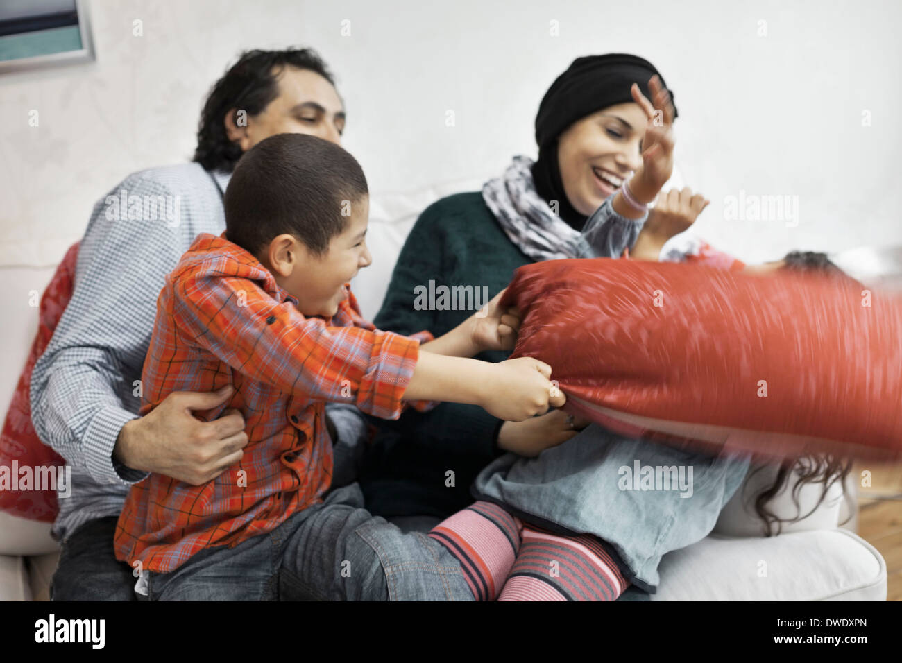 La famille musulmane ludique dans la salle de séjour Banque D'Images