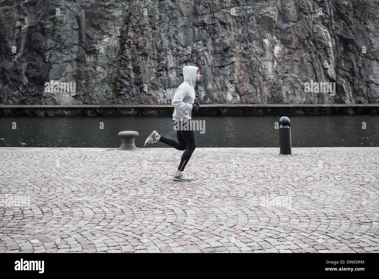 Man jogging on street contre rock Banque D'Images