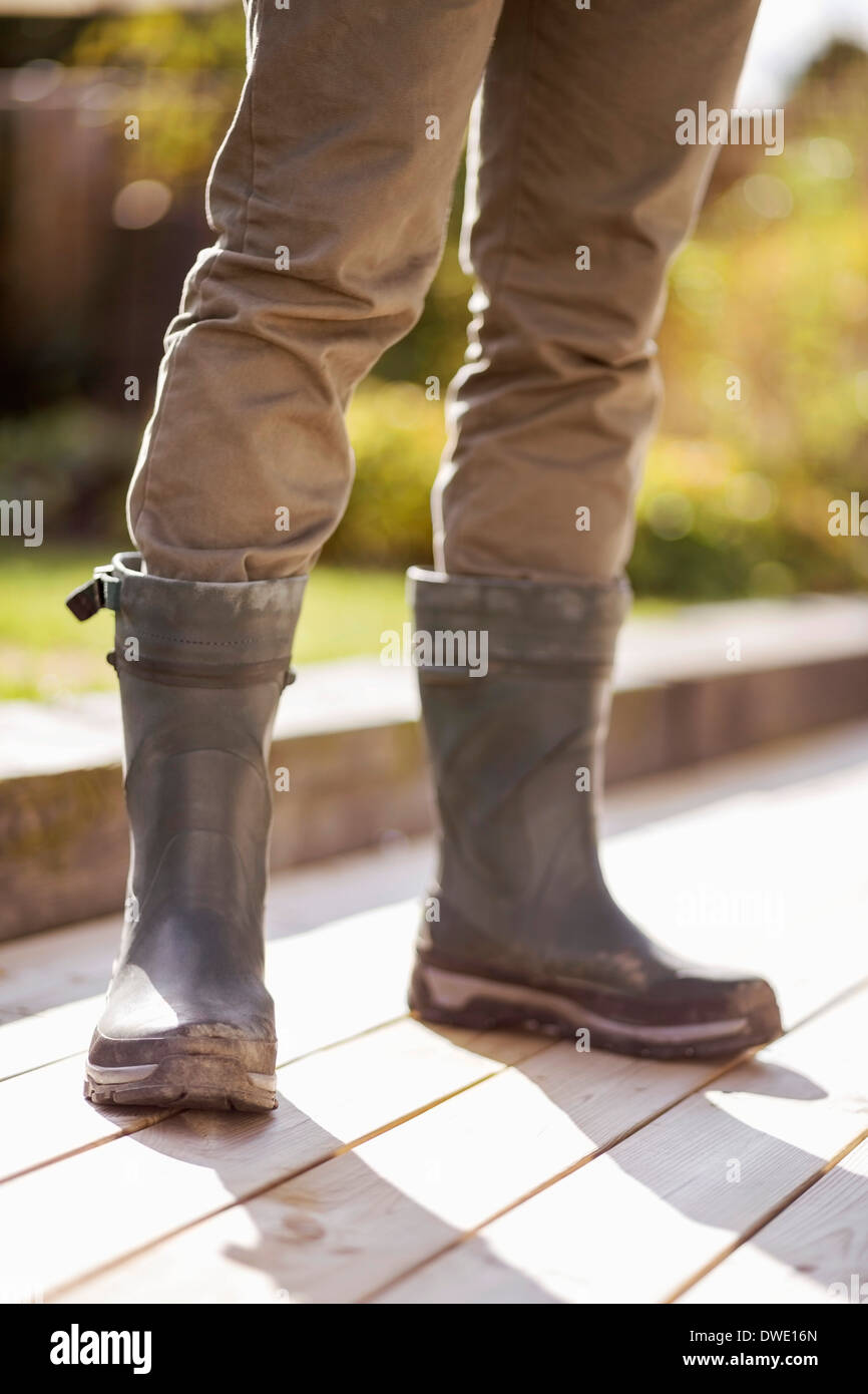 La section basse de l'homme dans des bottes en caoutchouc article at yard  Photo Stock - Alamy