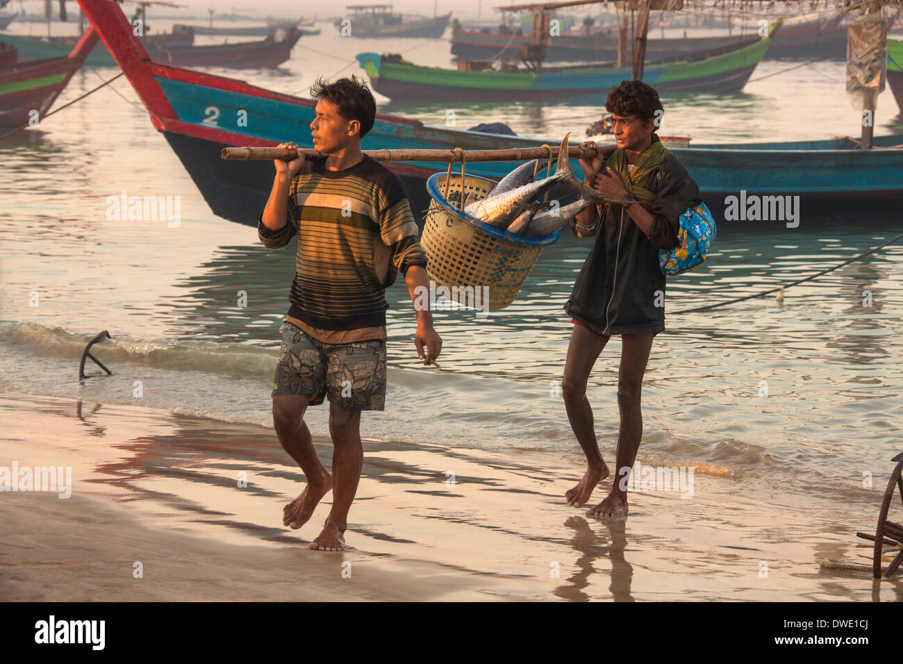 Les hommes portant le birman nuits à terre des prises à l'aube, près du village de pêcheurs à la plage de Ngapali - Myanmar (Birmanie) Banque D'Images