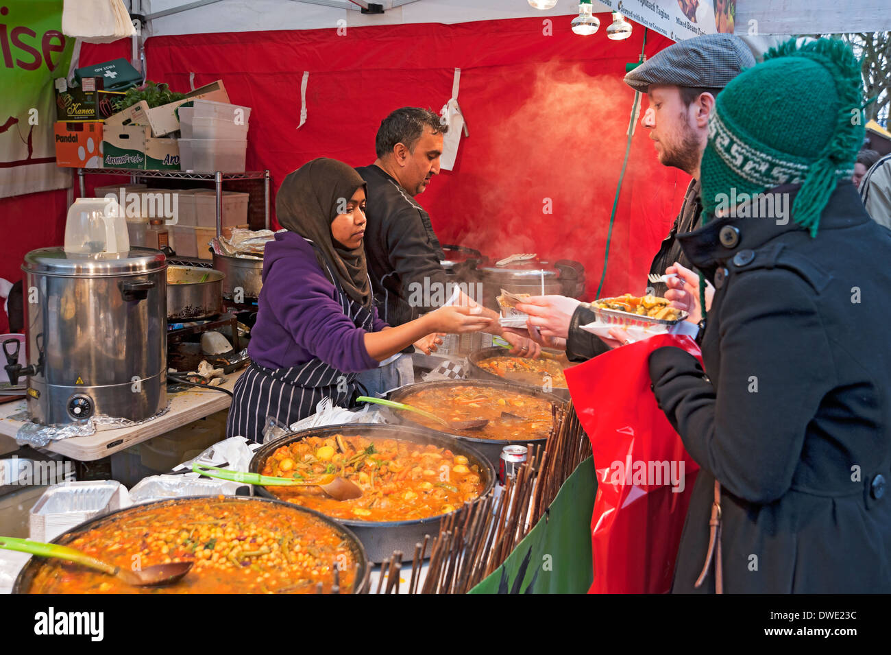 Jeune femme servant de la nourriture de rue marocaine sur le stand du marché York North Yorkshire Angleterre Royaume-Uni GB Grande-Bretagne Banque D'Images
