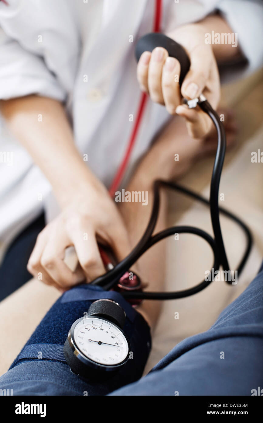 Portrait de femme médecin de prendre la pression artérielle du patient à la clinique Banque D'Images