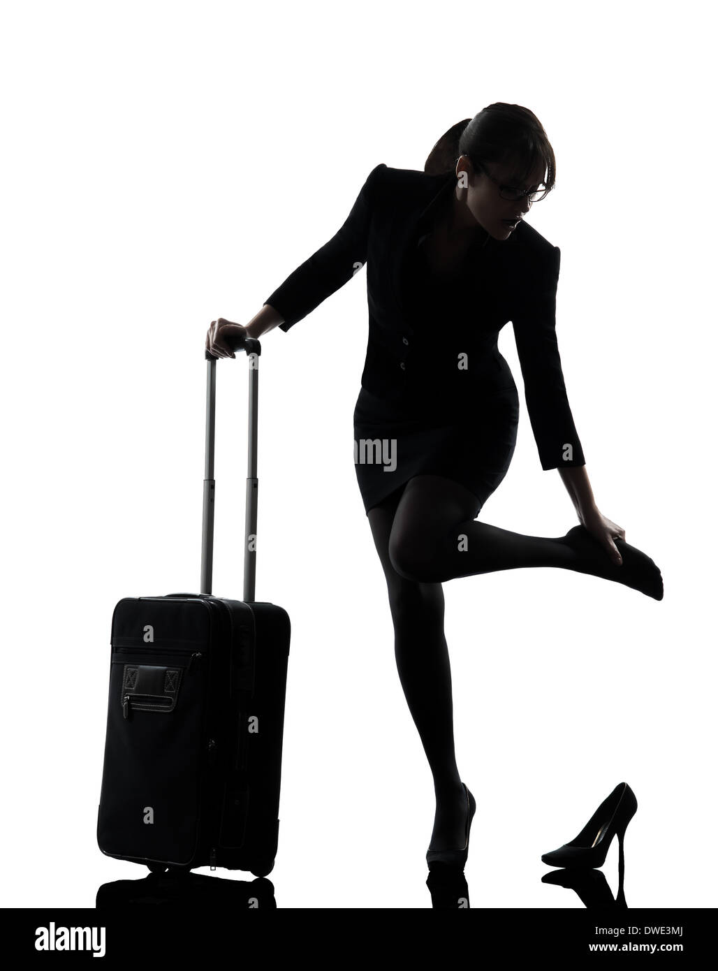 Une femme d'affaires voyageant pieds massage silhouette studio isolé sur fond blanc Banque D'Images