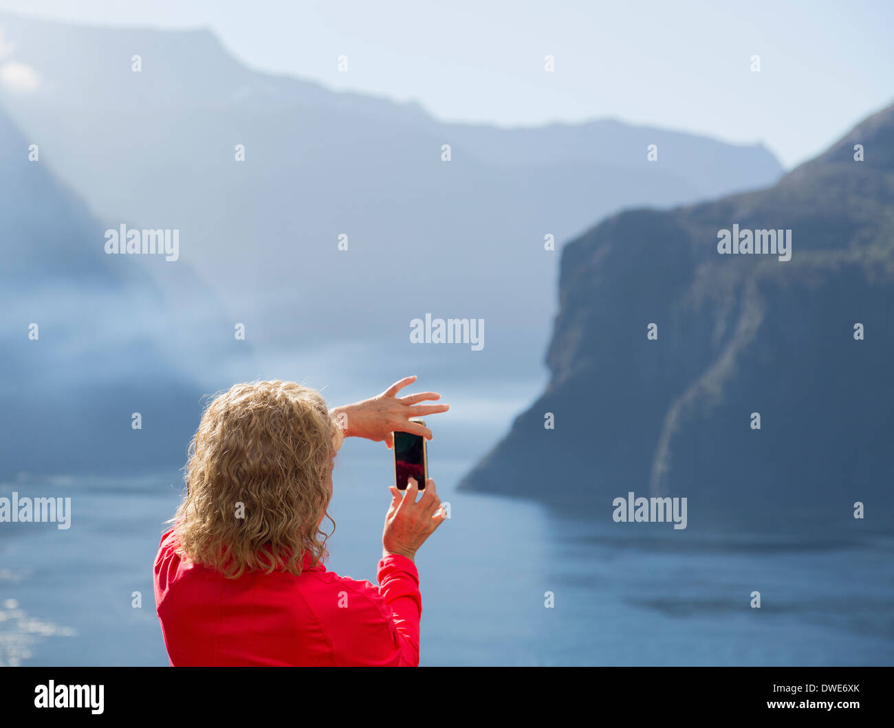 Passager sur bateau de croisière de prendre photo de Milford Sound sur l'île du sud de la Nouvelle-Zélande au début de matinée Banque D'Images