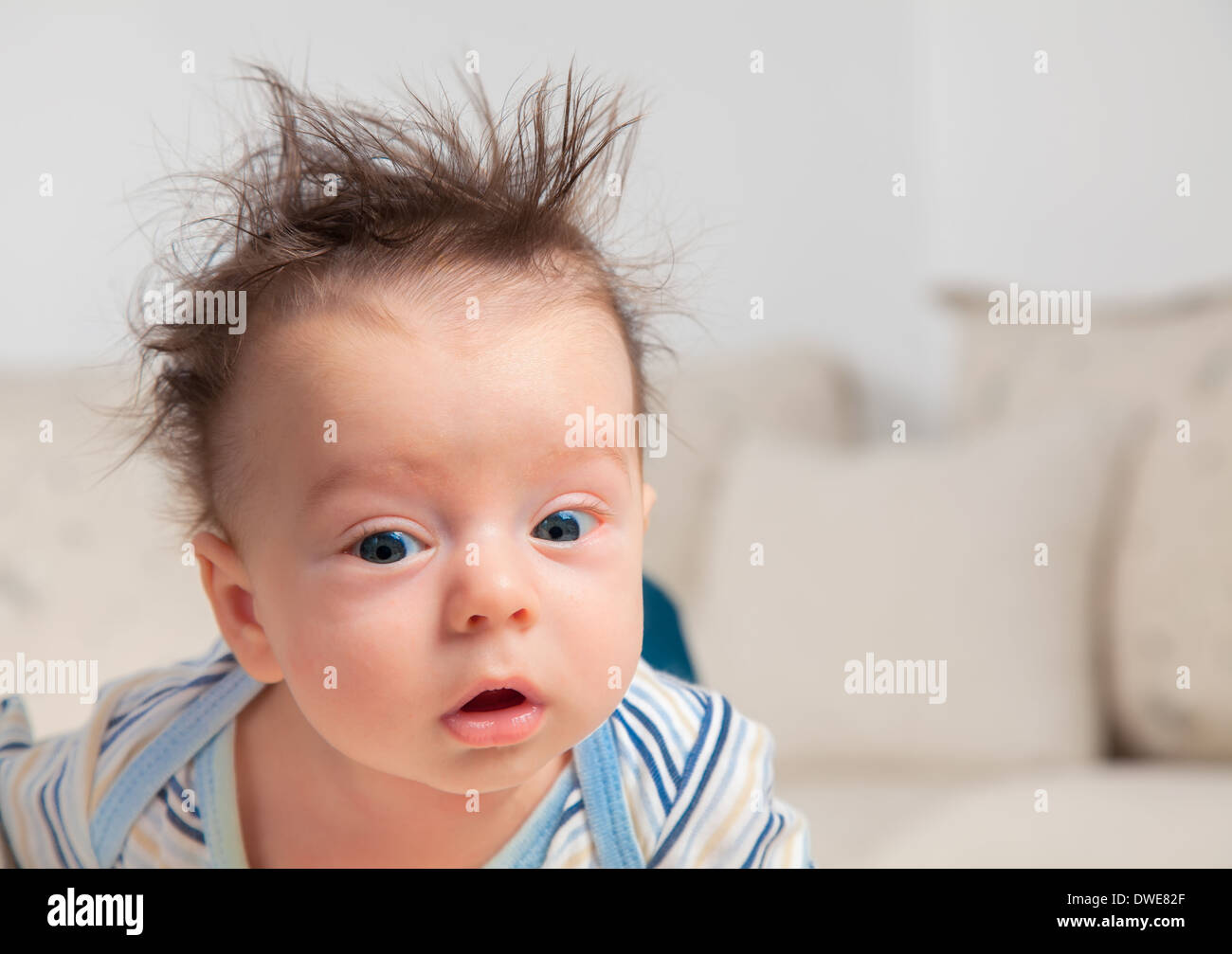 3 mois bébé garçon portrait avec les cheveux en désordre et somnolent. Banque D'Images