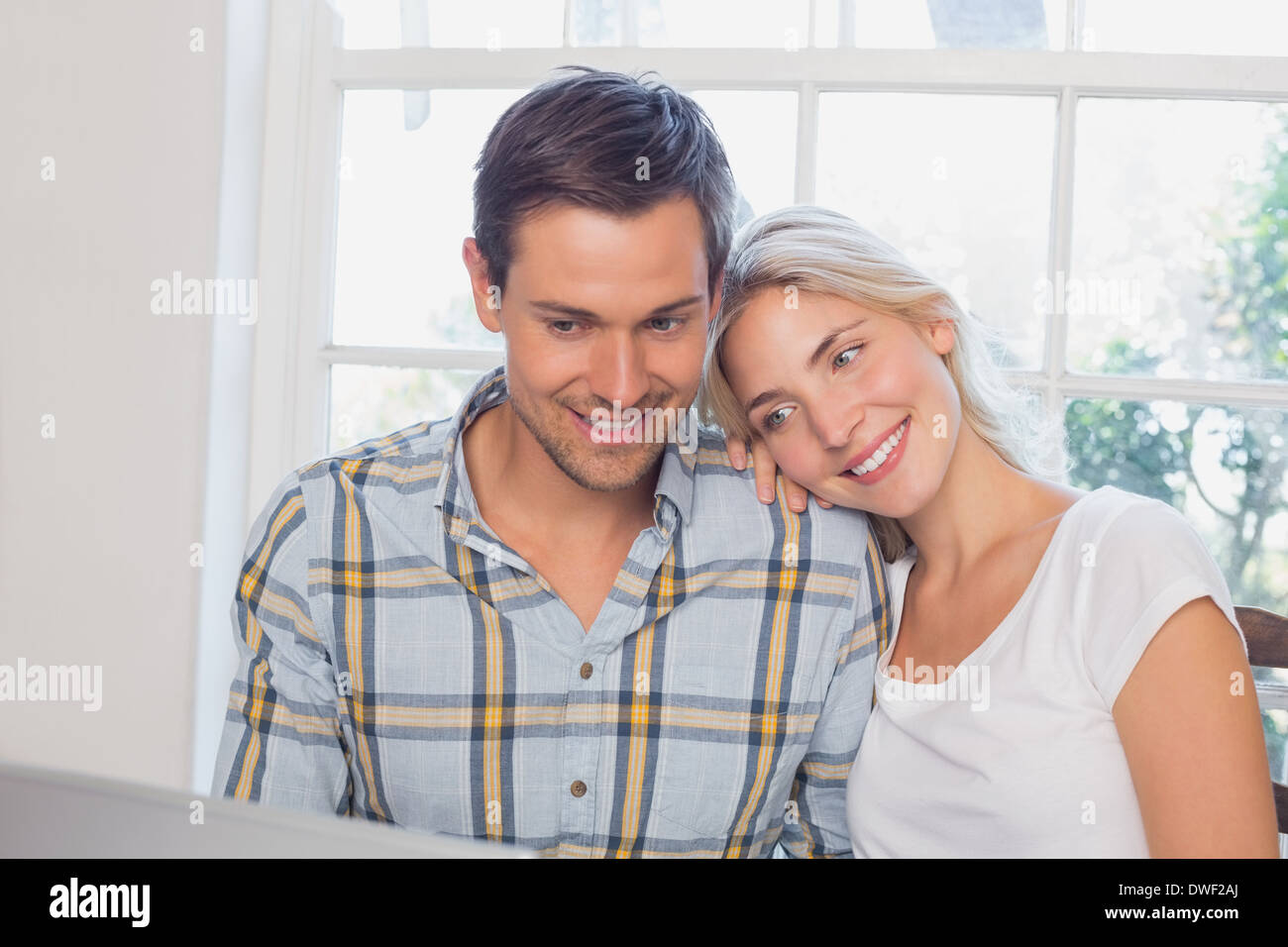 Heureux couple aimant avec laptop at home Banque D'Images