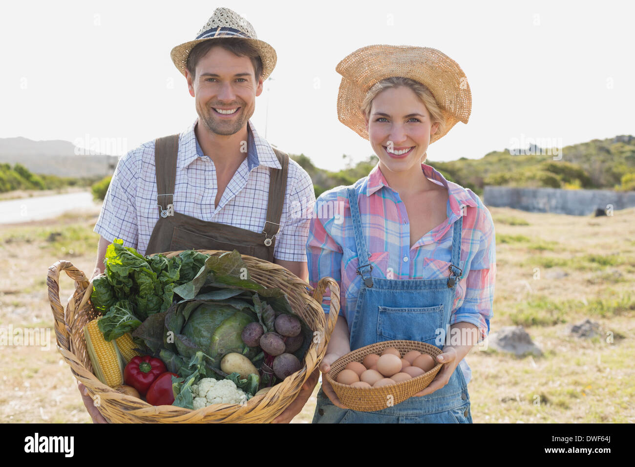 Smiling couple avec des légumes dans le champ Banque D'Images