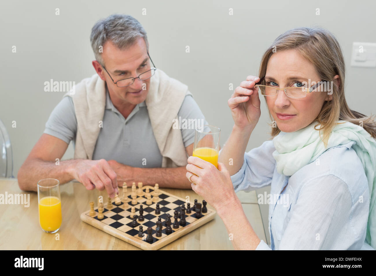 Couple jouant aux échecs tout en ayant du jus d'orange Banque D'Images