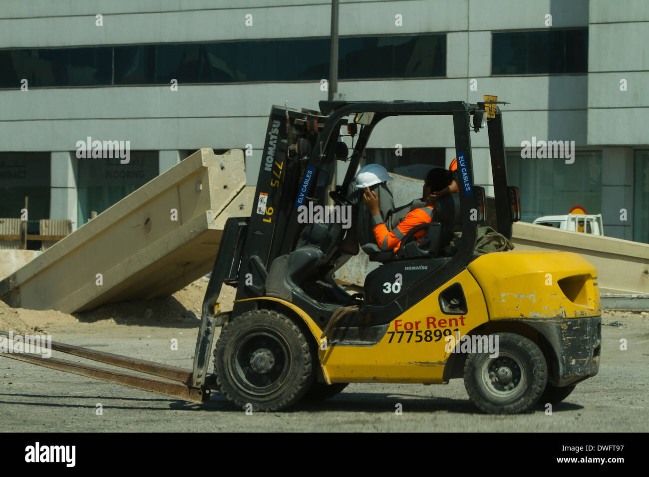 Conducteur de chariot élévateur prendre une sieste dormir Qatar construction Banque D'Images
