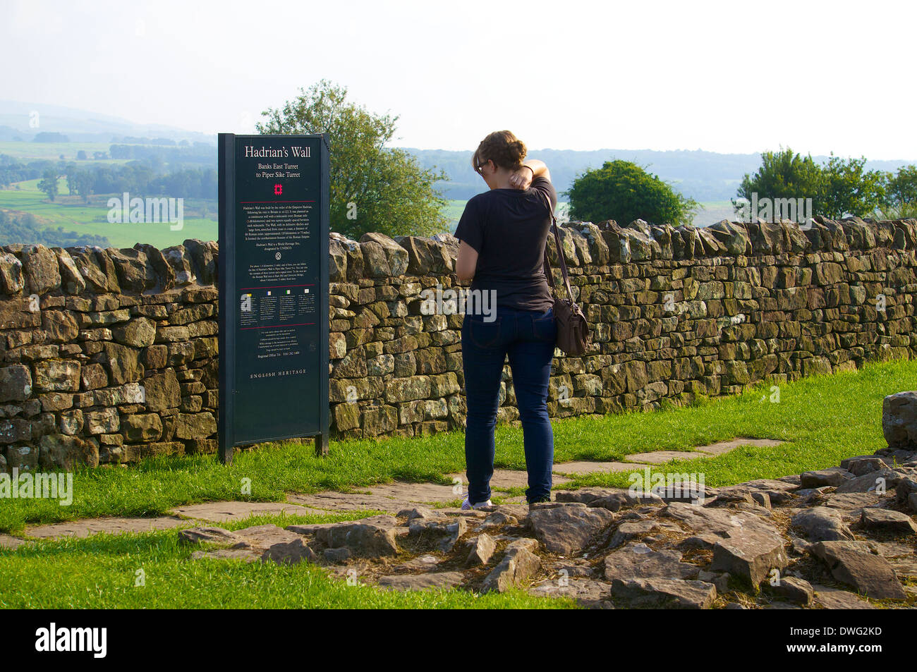 Les touristes à la recherche dans les banques à l'Est de l'information signe, tourelle Mur d'Hadrien, le Northumberland England Royaume-Uni Banque D'Images