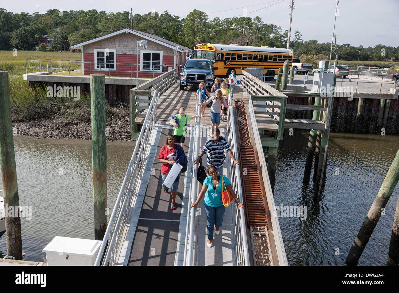 Les enfants de l'école à pied la rampe d'embarquement pour le ferry accueil à Sapelo Island, Géorgie. Une communauté Gullah historique isolé occupé par les descendants des esclaves sur une île de la mer au large de la côte de la Géorgie. Banque D'Images