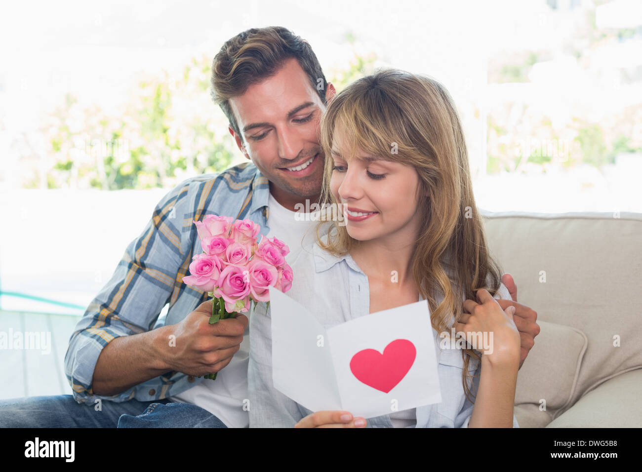 Couple aimant avec fleurs et carte de souhaits Banque D'Images