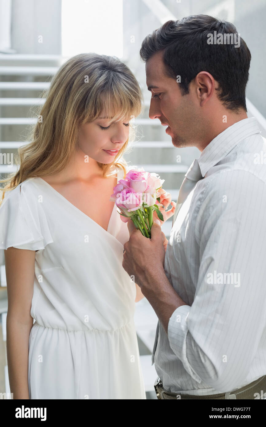 Jeune couple d'amour avec des fleurs à la maison Banque D'Images