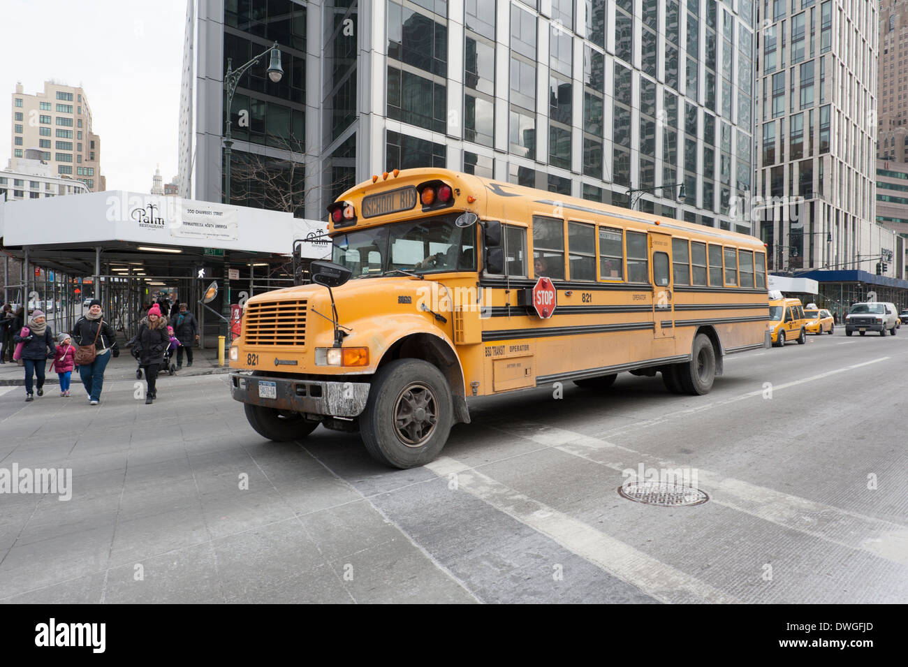 School bus sur West Street, dans le lower Manhattan, New York City, avec des mères et des enfants qui traversent la rue en face de lui. Banque D'Images