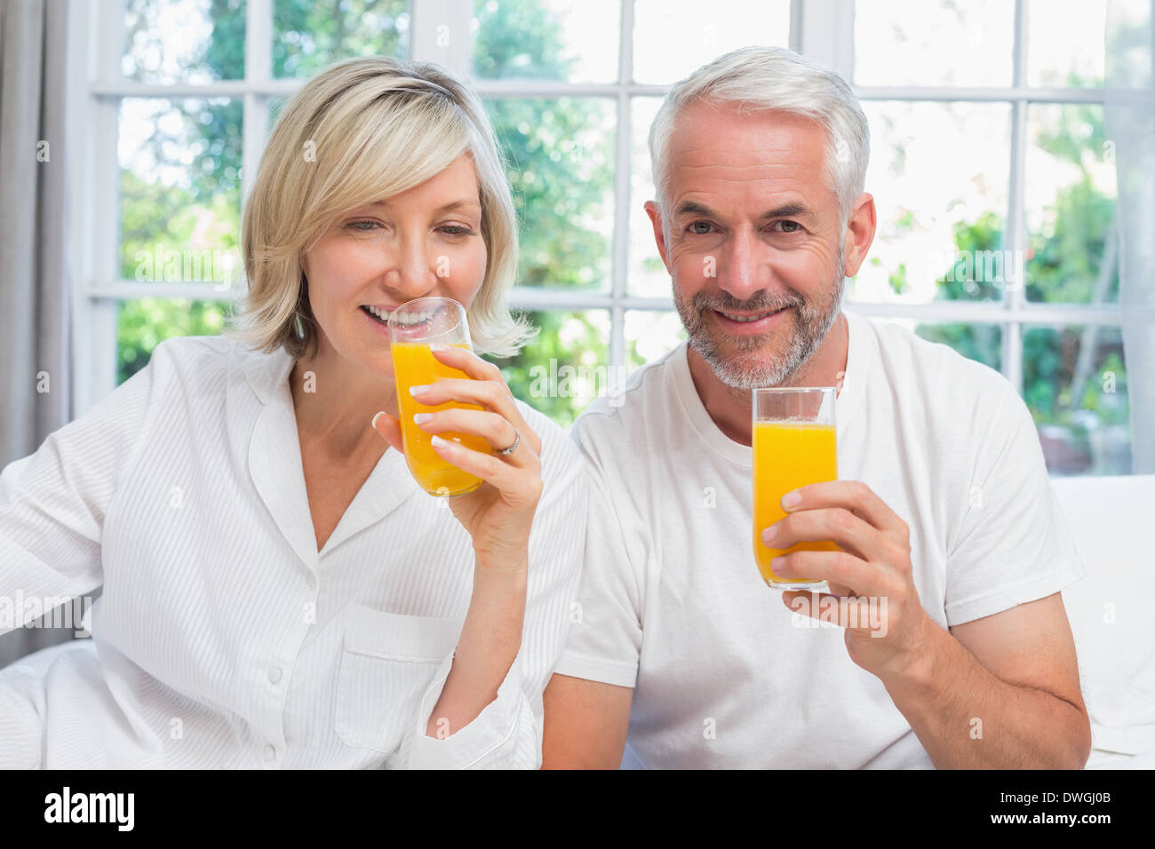Mature couple holding jus d'orange à la maison Banque D'Images