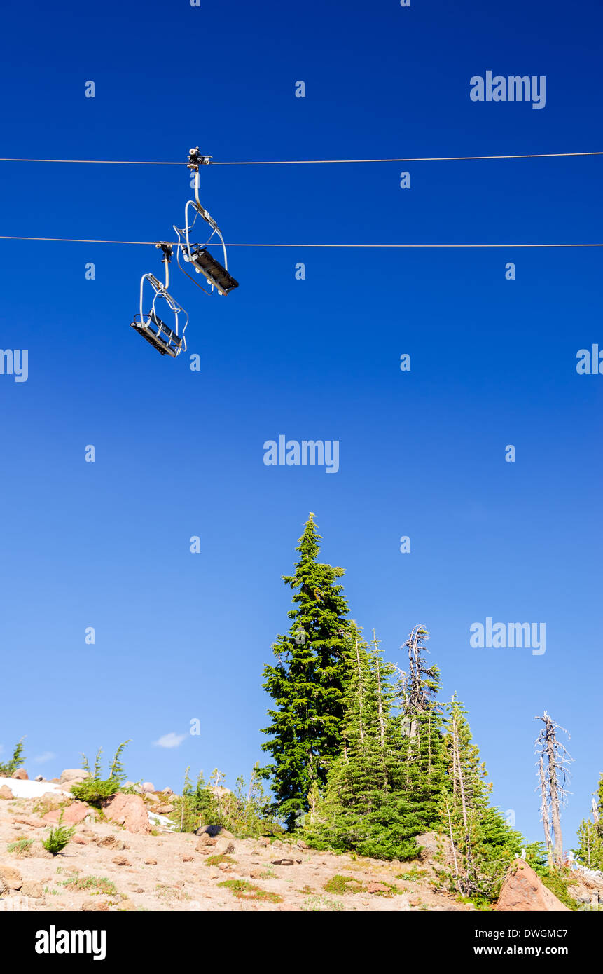 Ascenseur de ski avec un ciel bleu profond passant sur pins verts à l'été sur le mont Hood Banque D'Images