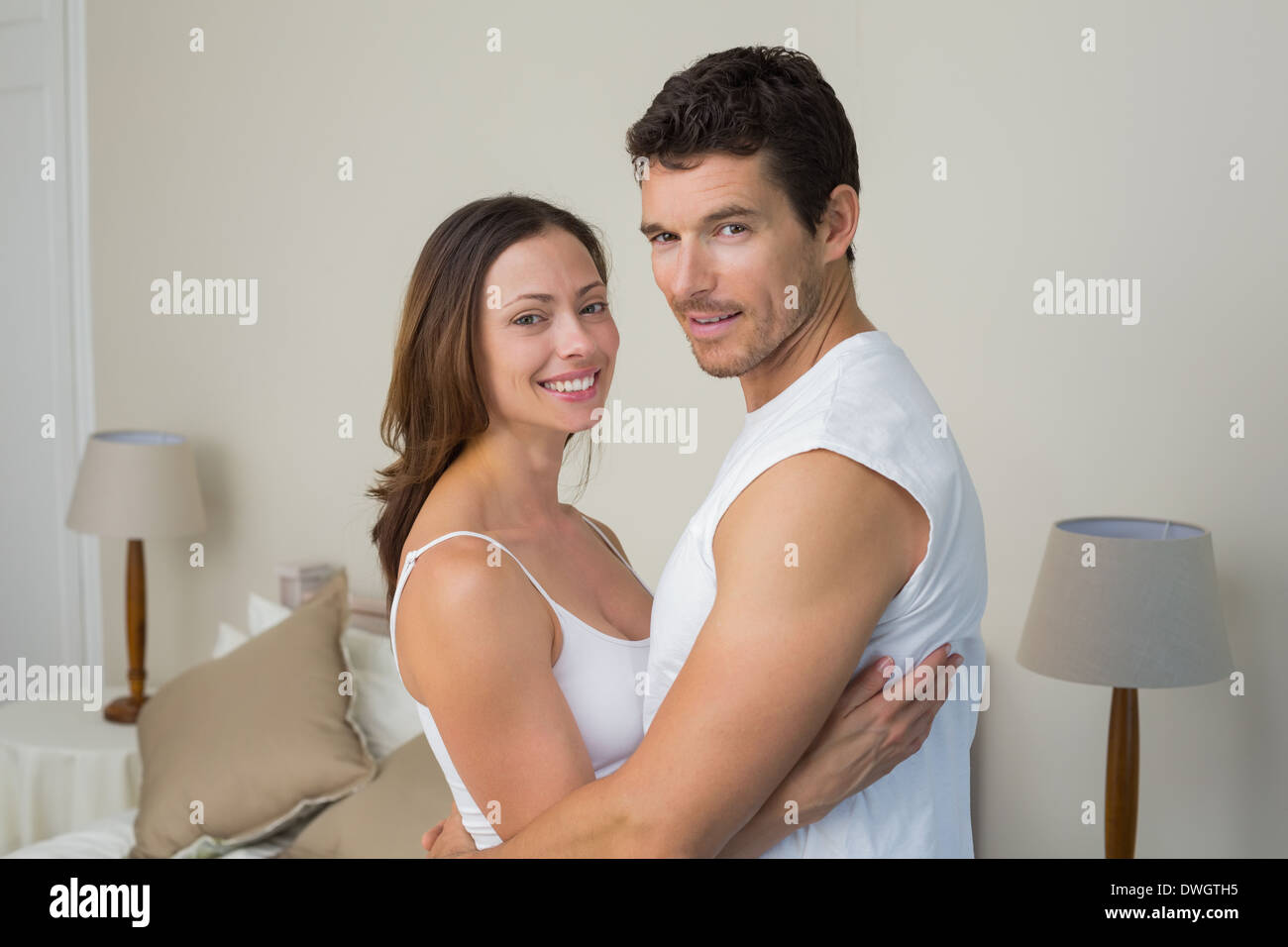 Couple heureux avec les bras autour à la maison Banque D'Images