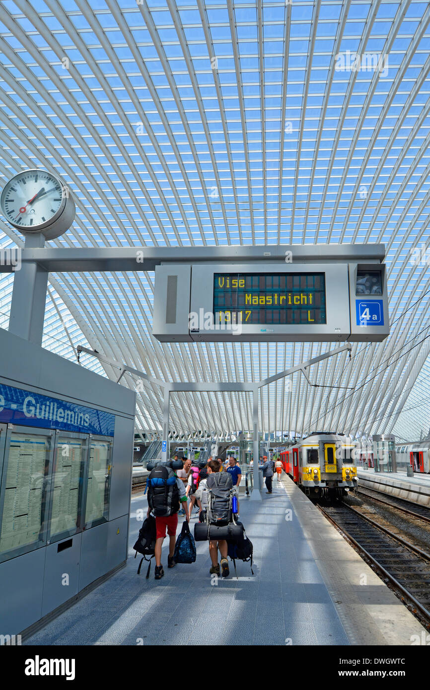 La plate-forme de la gare groupe Backpacker chargé avec kit de sac à dos dans les transports modernes de construction de toit verre conseil départs & réveil Belgique Liège Banque D'Images