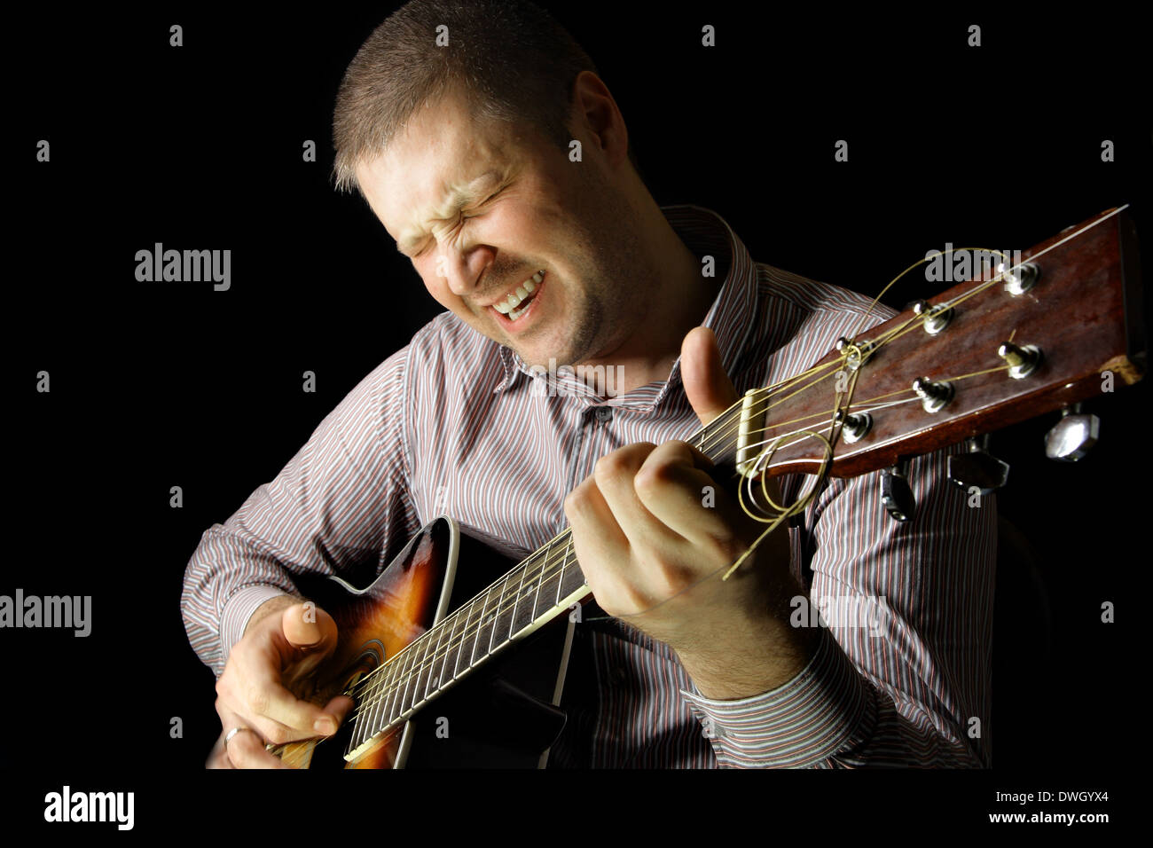 Homme avec guitare acoustique sur fond noir Banque D'Images