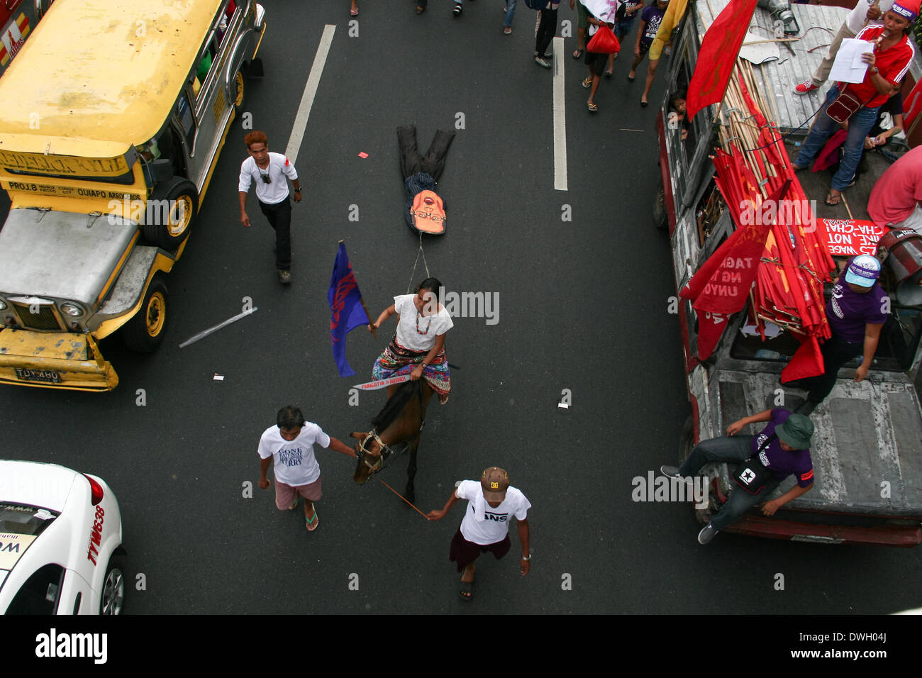 Manille, Philippines - 8 mars 2014 : une femme sur un cheval tirant une effigie du Président Aquino par Quezon Avenue pendant la Journée internationale de la femme à Manille. -- Des milliers de participants ont défilé jusqu'au pont Mendiola pour commémorer la Journée internationale des femmes. Conduire par Gabriela, un groupe de droits des femmes, les participants ont diffusé leur dégoût sur la prétendue inefficacité de l'administration Aquino pour gouverner. (Photo by Gerard Seguia/Pacific Press/Alamy Live News) Banque D'Images