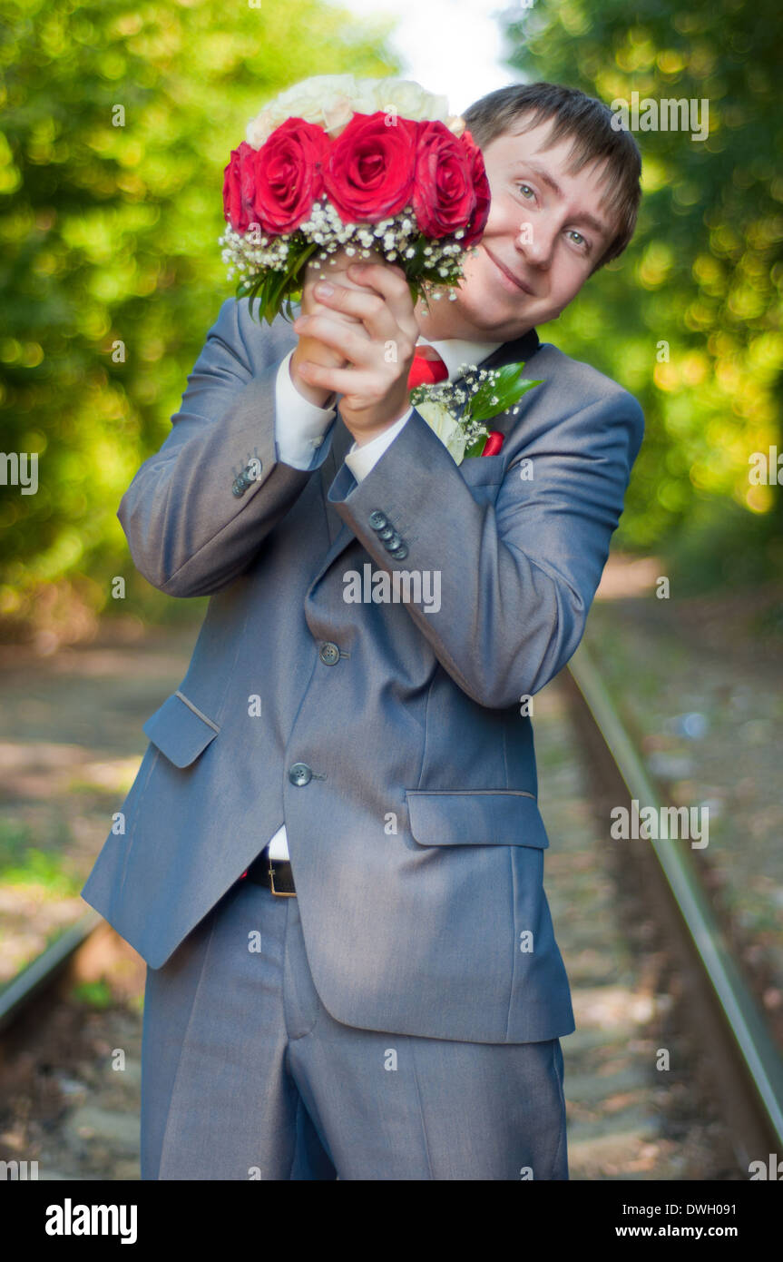 La belle jeune marié d'un bouquet de roses rouge et blanc sur une piste de l'été Banque D'Images