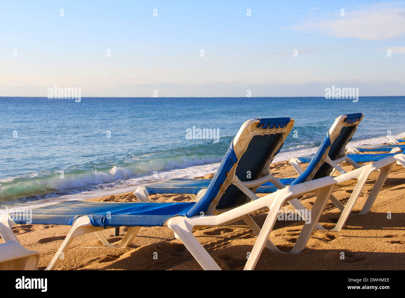 Chaises de plage sur le sable de l'océan, plage ob Costa Brava, Espagne Banque D'Images