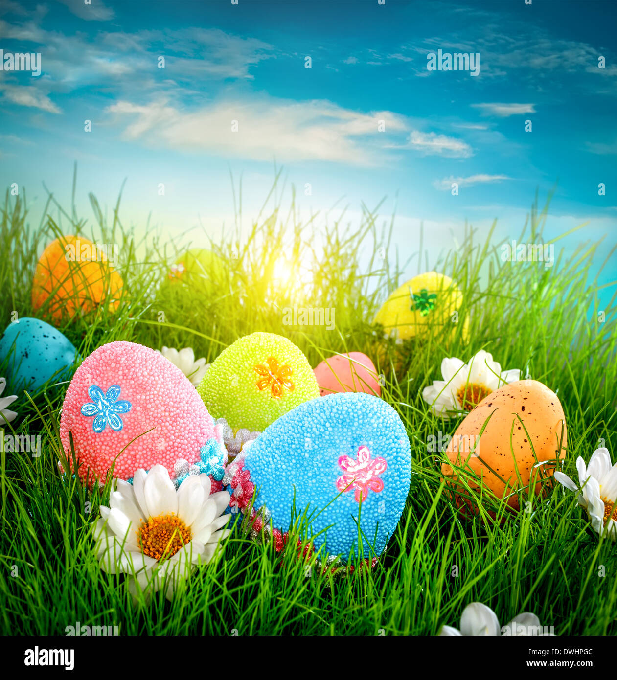 Oeufs de Pâques décorés dans l'herbe sur fond de ciel bleu Banque D'Images