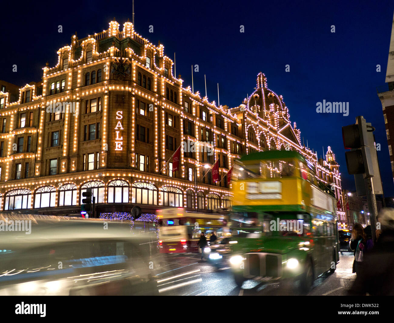 GRAND magasin HARRODS DE VENTE la nuit avec le signe « Sale » des acheteurs Et rétro de marque Harrods et trafic de passage Knightsbridge Londres SW1 Banque D'Images