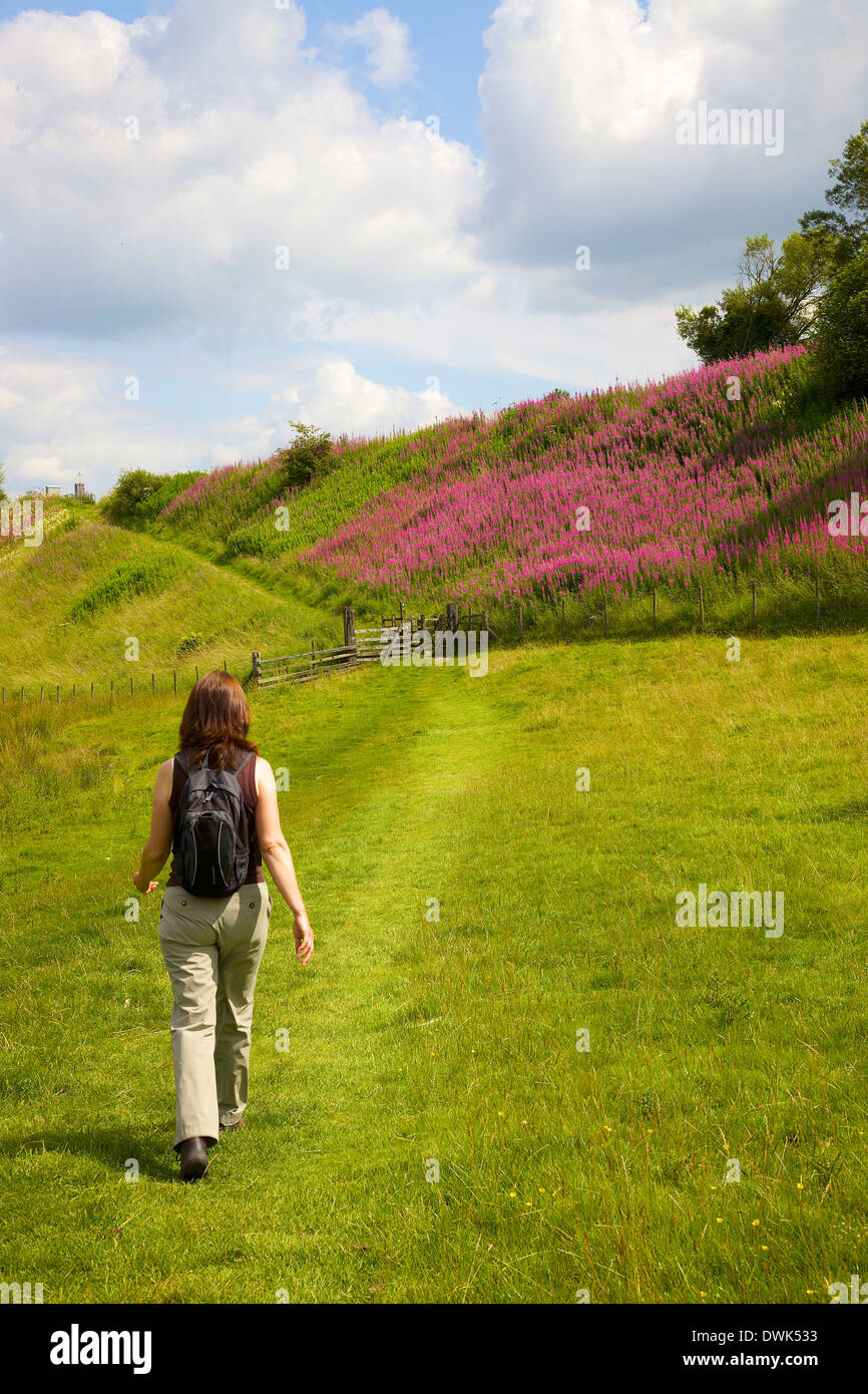 Randonneur Femme à marcher en direction de remblai de chemin de fer près de Gilsland Mur d'Hadrien, Cumbria England Royaume-Uni Banque D'Images