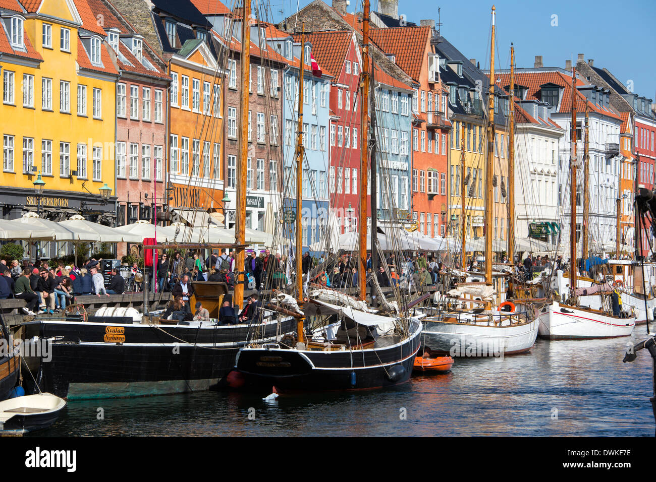 Bateaux amarrés le long des bâtiments historiques peints de couleurs vives à Copenhague Nyhavn Banque D'Images