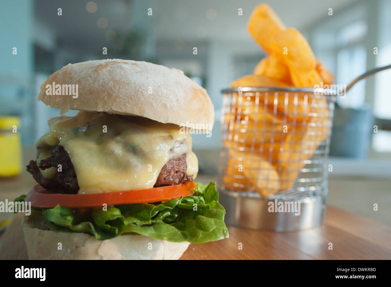 Avec un ordre latéral Beefburger de frites ou ébréchées, les pommes de terre avec une salade au fromage fondu de remplissage et du bacon comme un extra. Banque D'Images