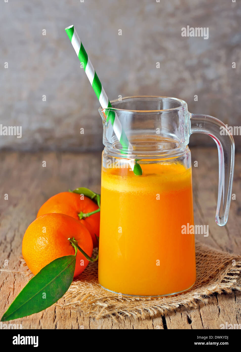 Jus de mandarine fraîchement pressé sur un fond de bois Banque D'Images