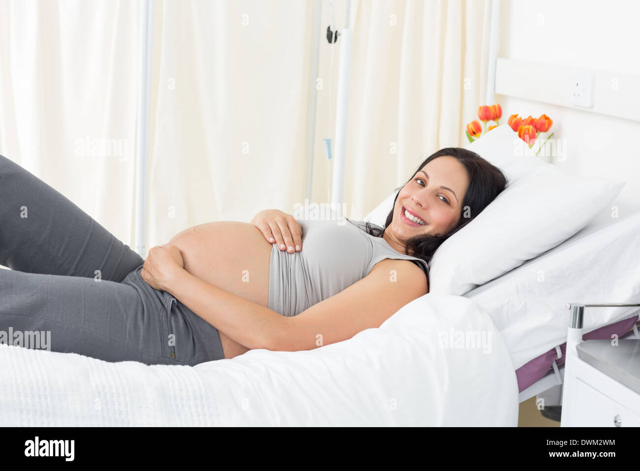 Smiling pregnant woman lying in hospital Banque D'Images