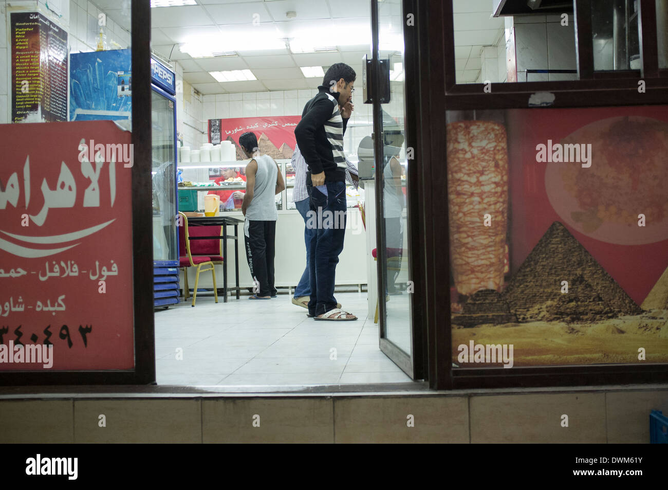 Les hommes d'acheter de la nourriture dans un snack-bar. Vieille ville de Doha, au Qatar Banque D'Images
