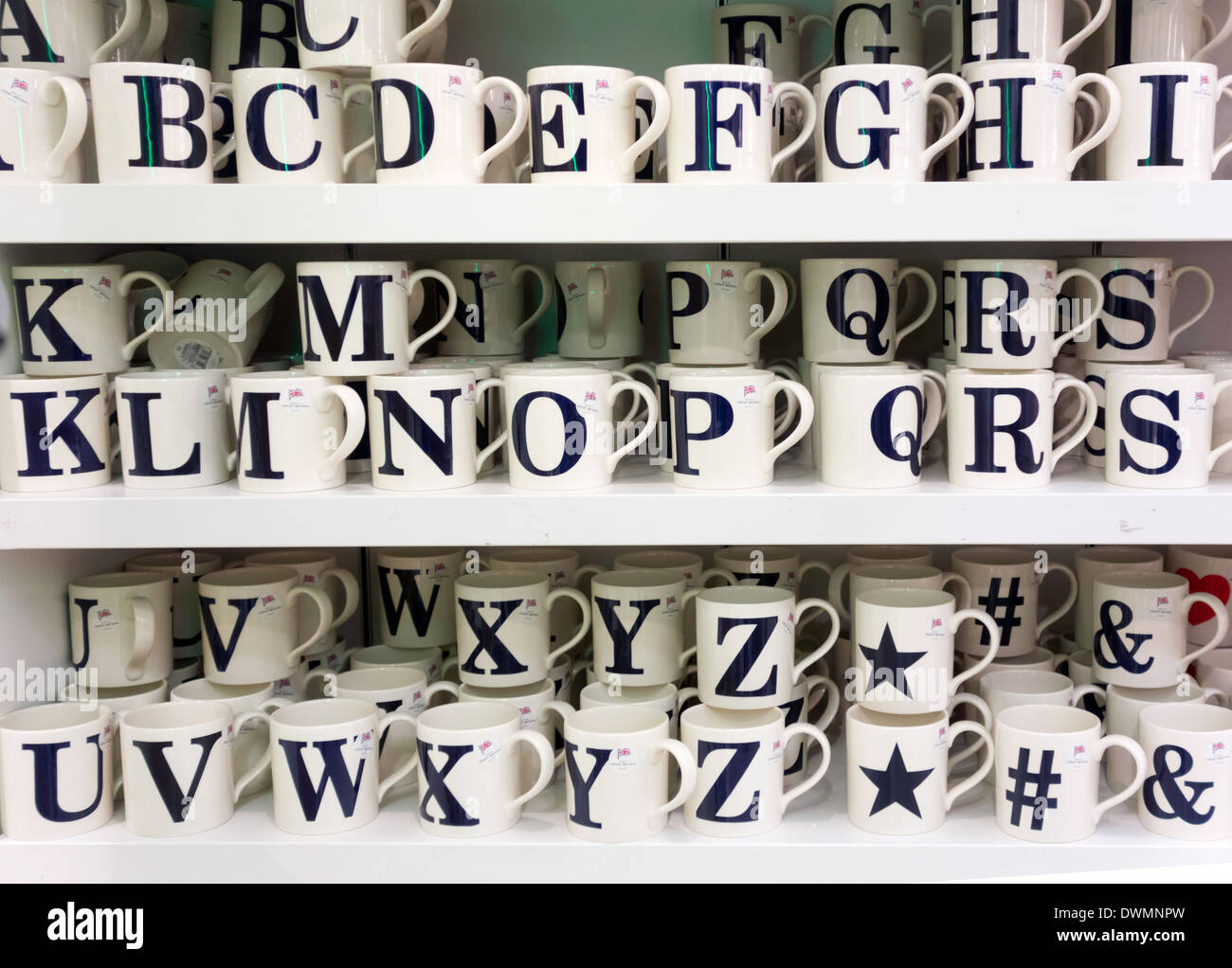 Affichage des tasses de Chine blanc chacune décorée avec une seule lettre de l'alphabet Banque D'Images Affichage des tasses de Chine blanc chacune décorée avec une seule lettre de l'alphabet Banque D'Images