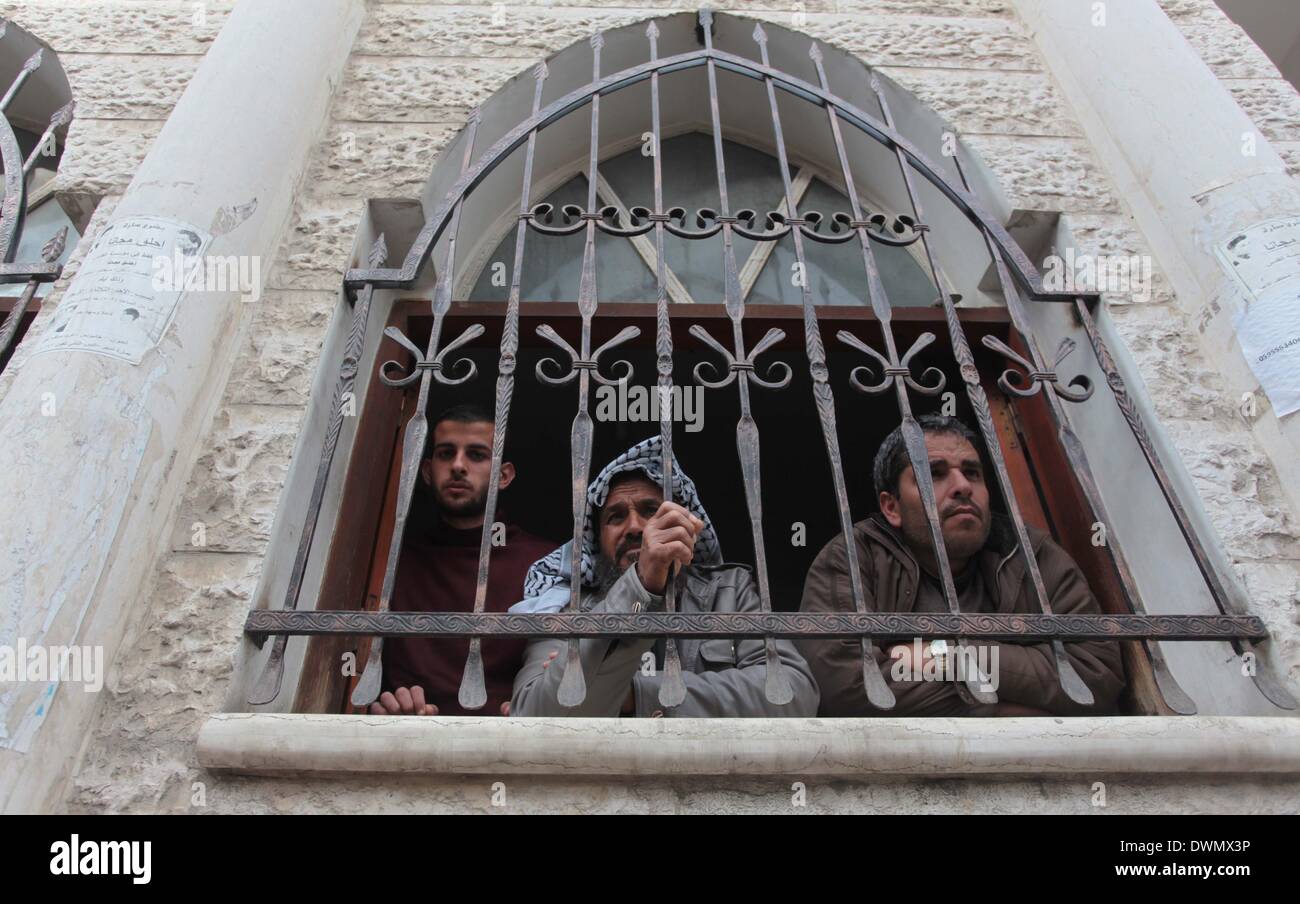 Khan Younis, dans la bande de Gaza, territoire palestinien. Mar 11, 2014. Regardez sur les Palestiniens lors des funérailles de trois camarades, qui ont été tués dans une frappe aérienne israélienne à Khan Younis, dans le sud de la bande de Gaza le 11 mars 2014. Une frappe aérienne israélienne a tué mardi trois militants palestiniens dans la bande de Gaza, le groupe du Jihad islamique a dit. L'armée israélienne a déclaré qu'un des avions israéliens membres du Djihad islamique qui avait tiré un obus de mortier à ses forces, et ''direct hits ont été confirmés : Crédit Ashraf Amra/APA Images/ZUMAPRESS.com/Alamy Live News Banque D'Images