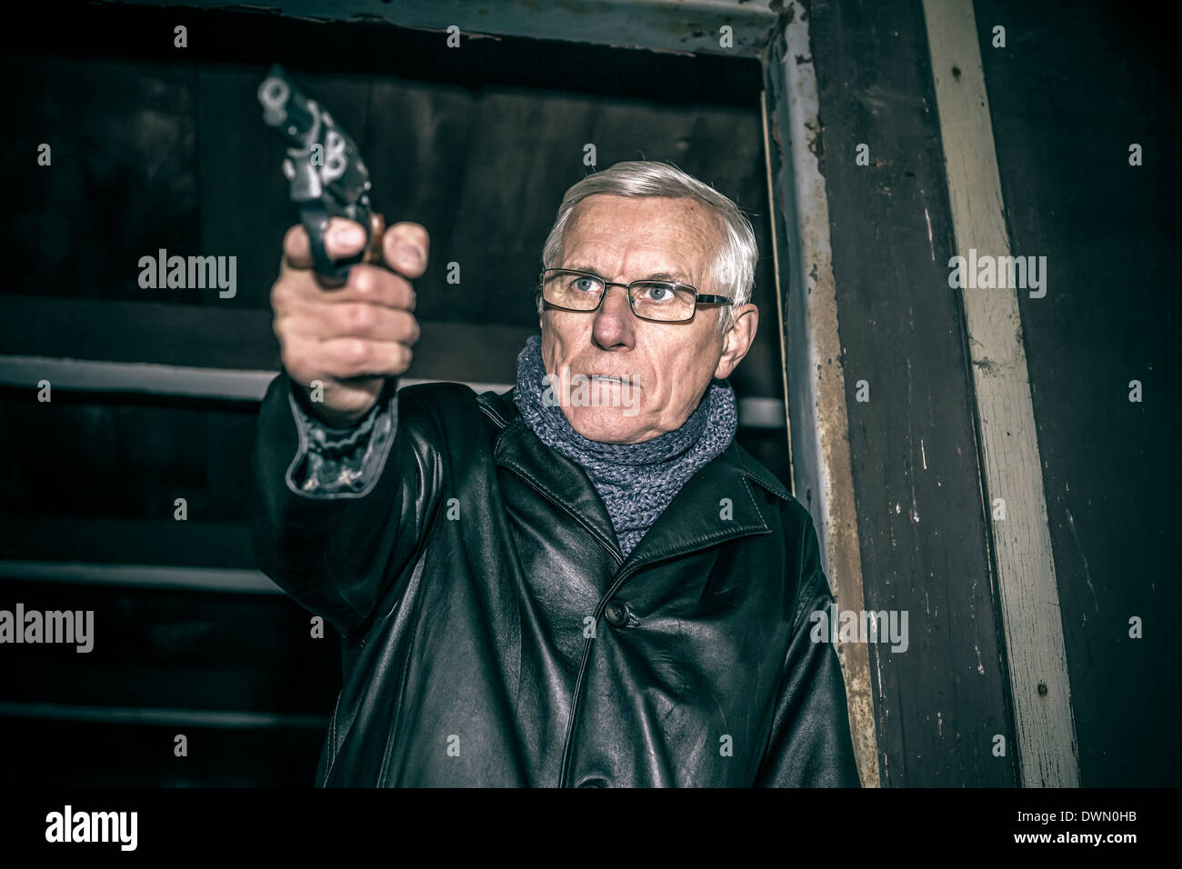 Man dangereuses visant une arme à feu et de l'article dans la vieille cabine sombre. Banque D'Images