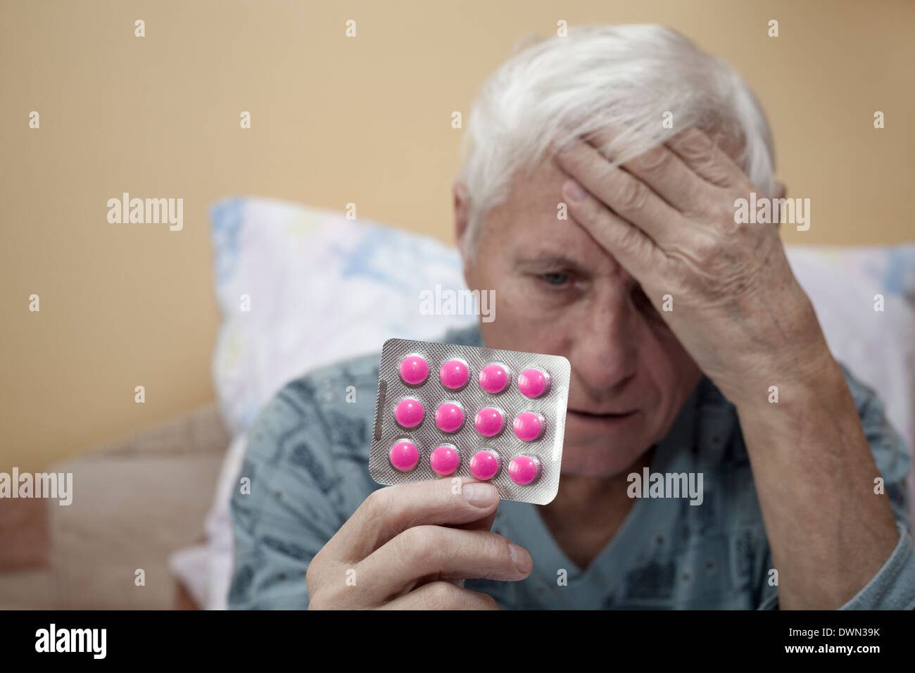 Senior man holding de tête avec des antalgiques. Banque D'Images