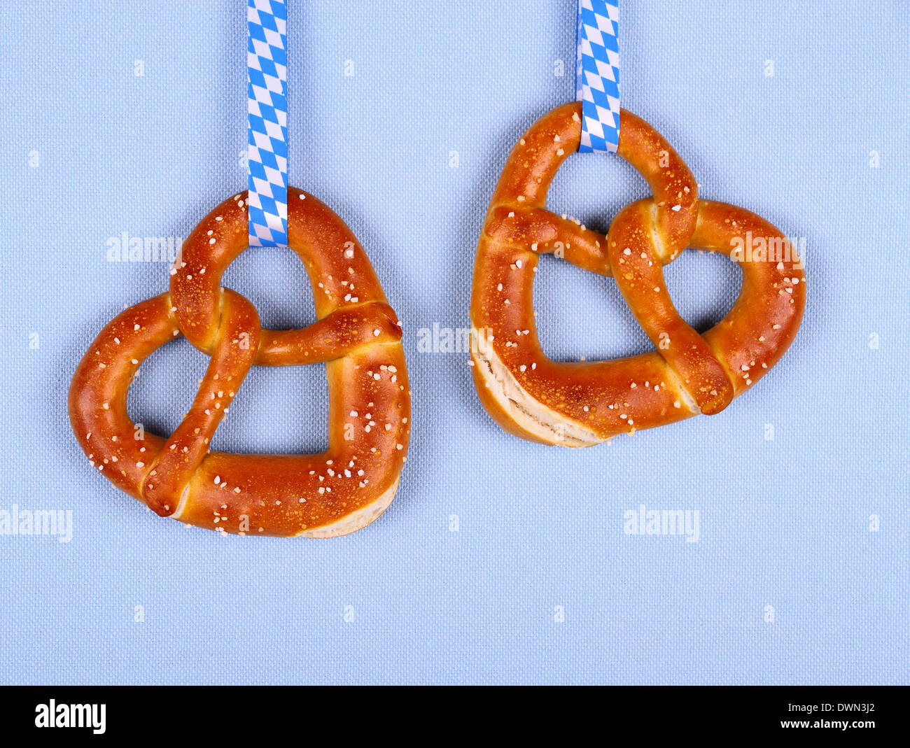 Deux bretzel en forme de coeur sur fond bleu, vue d'en haut Banque D'Images